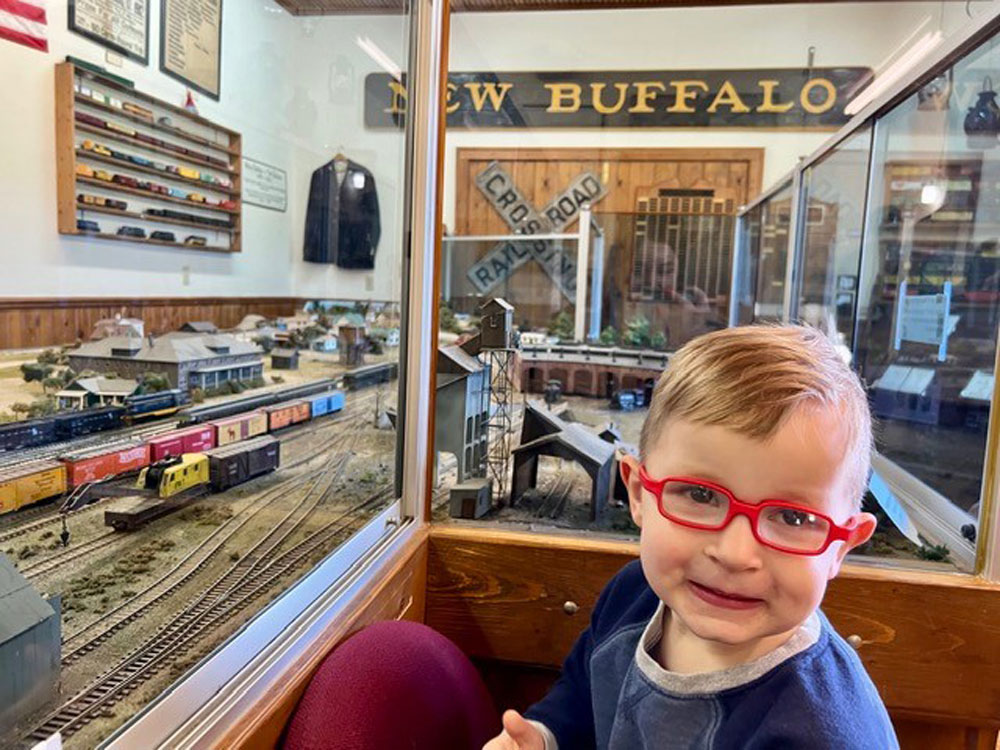 Young boy posing next to the miniature model of new buffalo's railroad