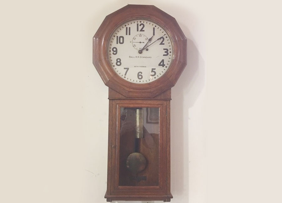 antique classic railroad clock with dark wood and pendulum