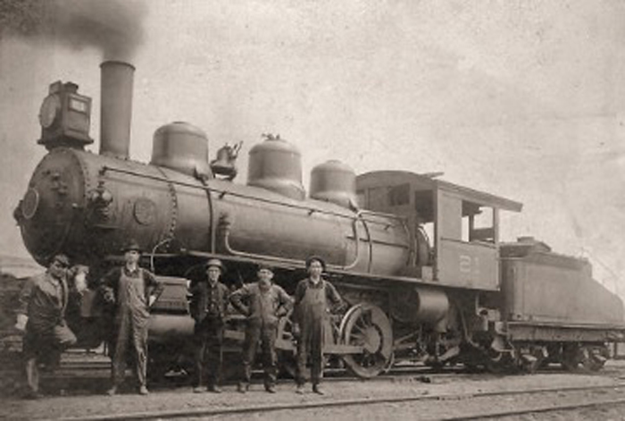 Photo of working class men posing in fron of a 1940's train